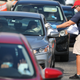 City of Hialeah employee Miguel Diaz hands out paper unemployment applications to people in their vehicles in front of the John F. Kennedy Library in Hialeah, FL. (April 8, 2020)